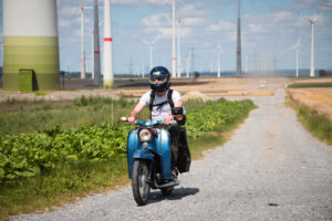 Blaue Simson Schwalbe vor Windkraftwerken